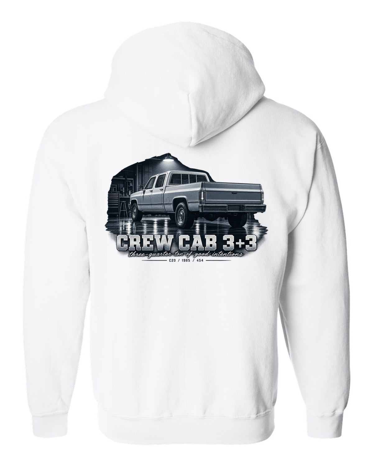 1985 C20 Squarebody crew cab in a garage night scene, print white zip hoodie back view with the design