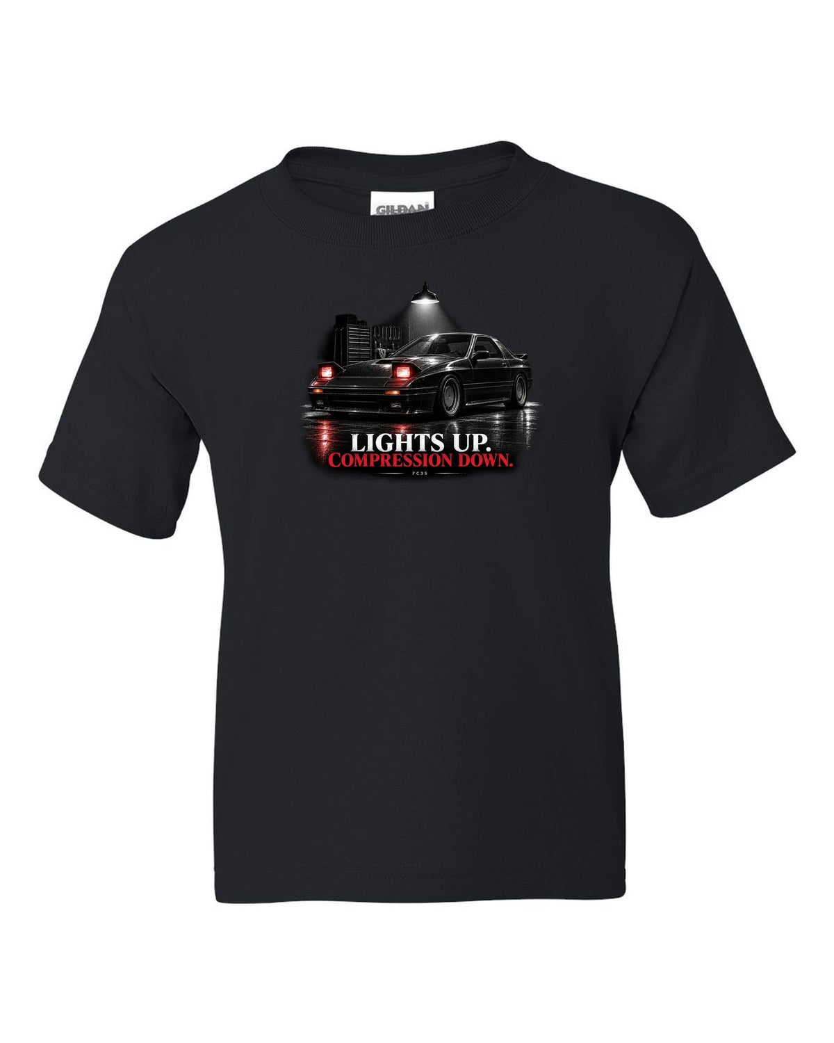 Low front three-quarter Mazda RX-7 FC3S Turbo II in a garage at night black kids tee front view with the design