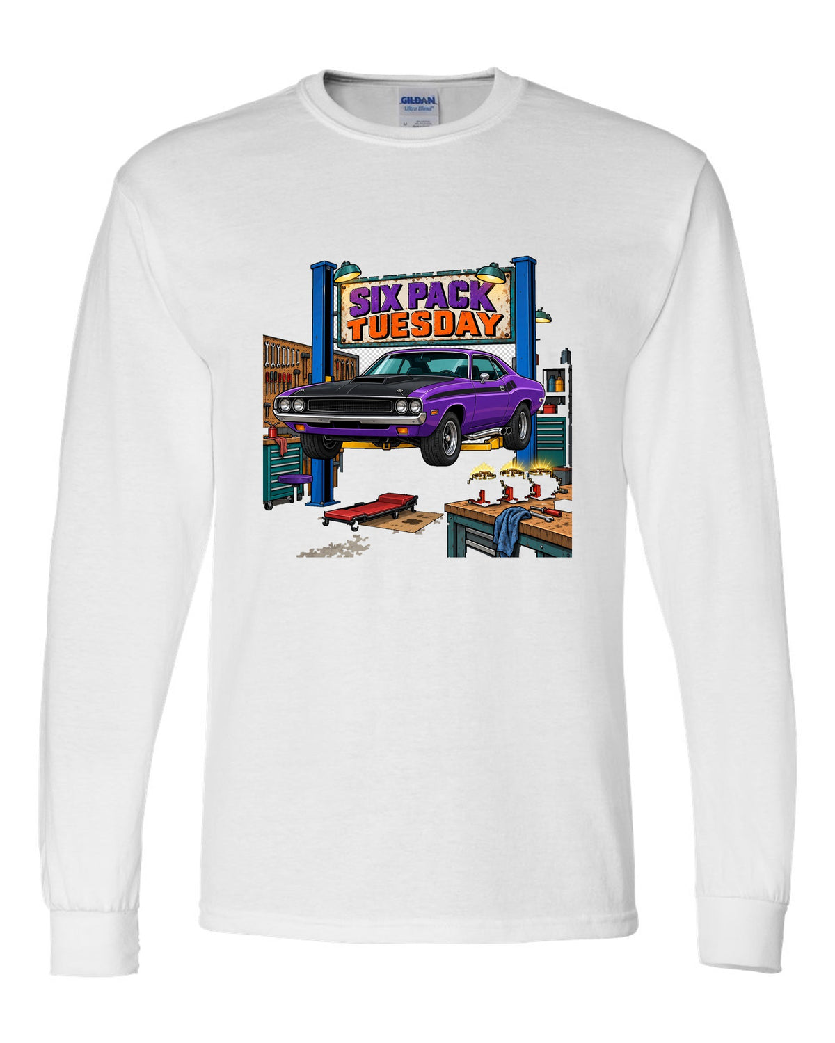Garage workshop scene with a 1970 Dodge Challenger T/A on a lift and Six Pack Tuesday text white long sleeve front view with the design