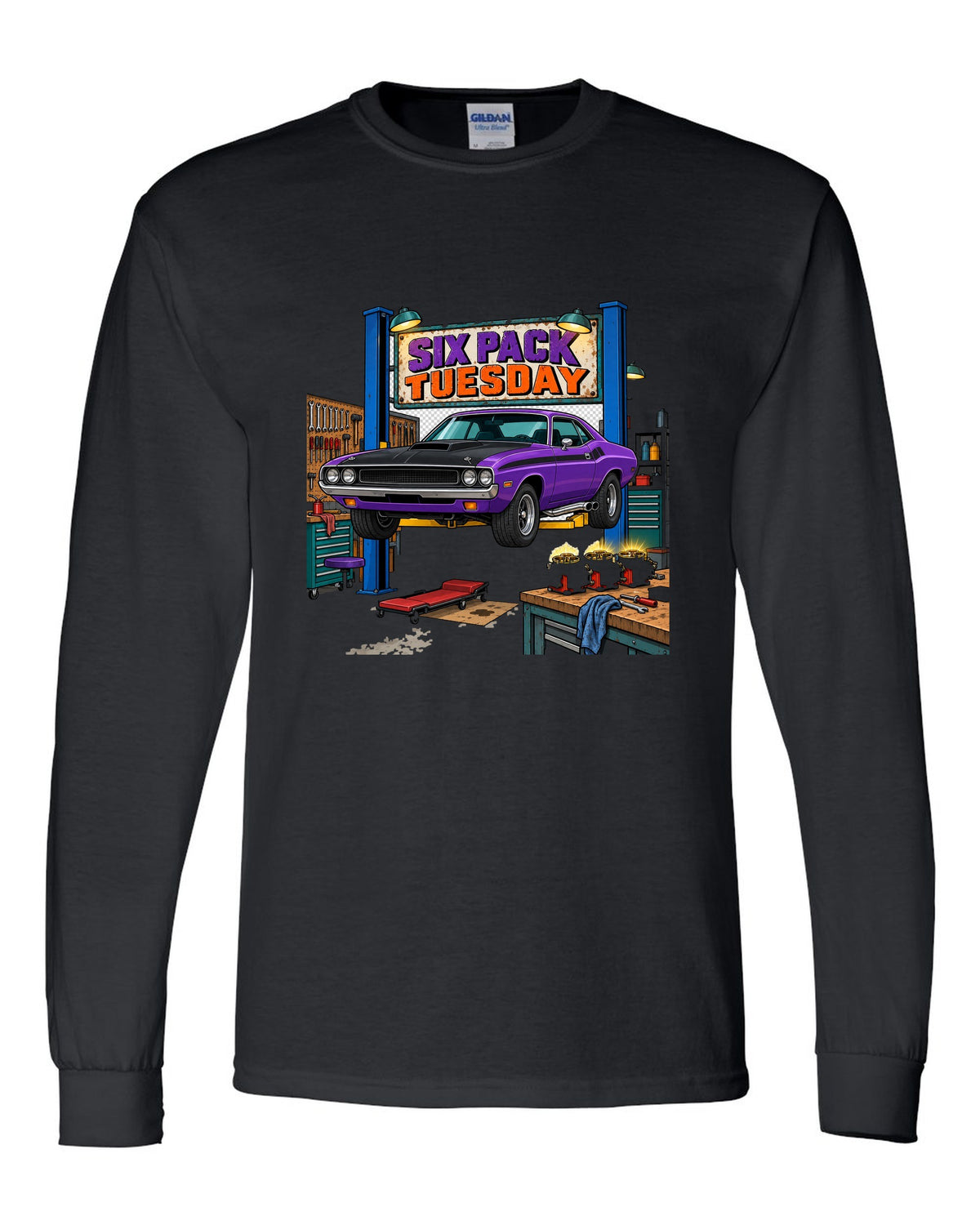 Garage workshop scene with a 1970 Dodge Challenger T/A on a lift and Six Pack Tuesday text black long sleeve front view with the design