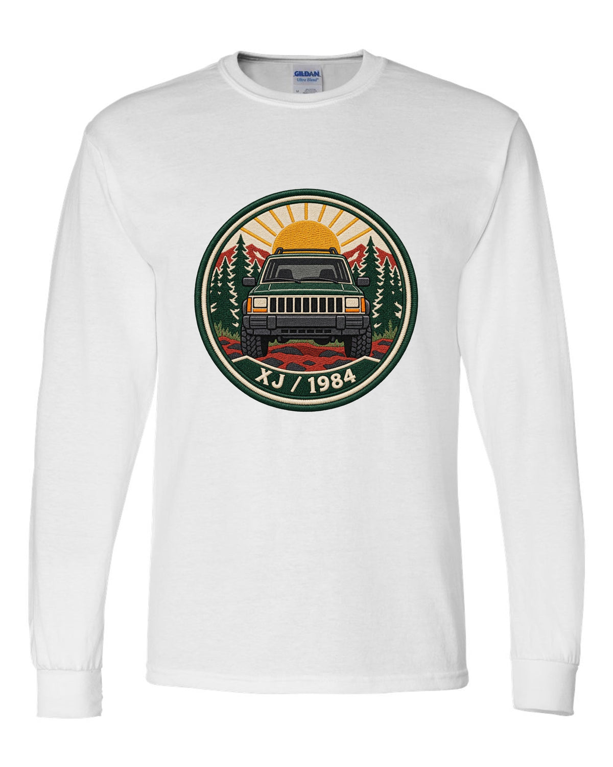 Round embroidered-style crest print of a boxy Jeep Cherokee XJ with XJ 1984 text white long sleeve front view with the design