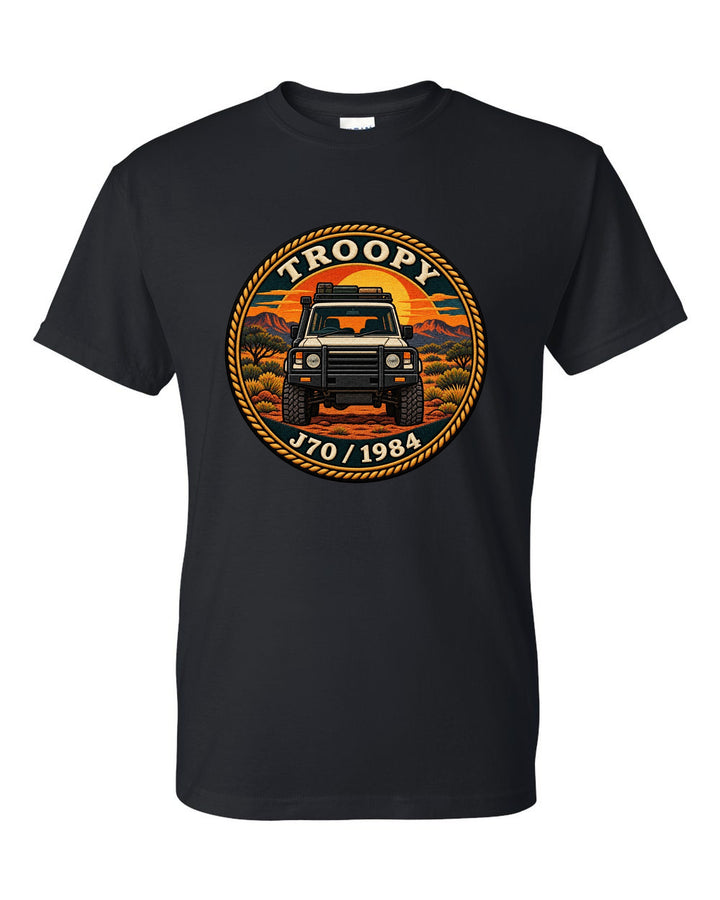 Sunset stamp patch crest of a Toyota Land Cruiser J70 troop carrier with the word Troopy black t-shirt front view with the design