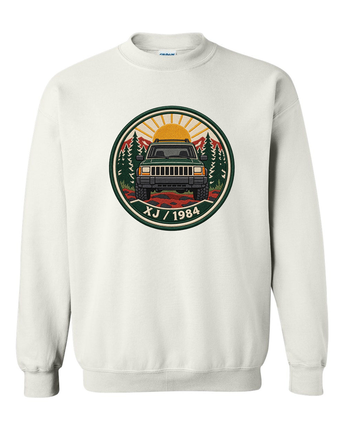 Round embroidered-style crest print of a boxy Jeep Cherokee XJ with XJ 1984 text white crewneck front view with the design