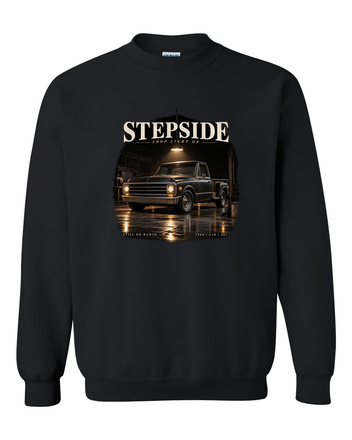 Chevy C10 Stepside under a shop light, garage night print black crewneck front view with the design