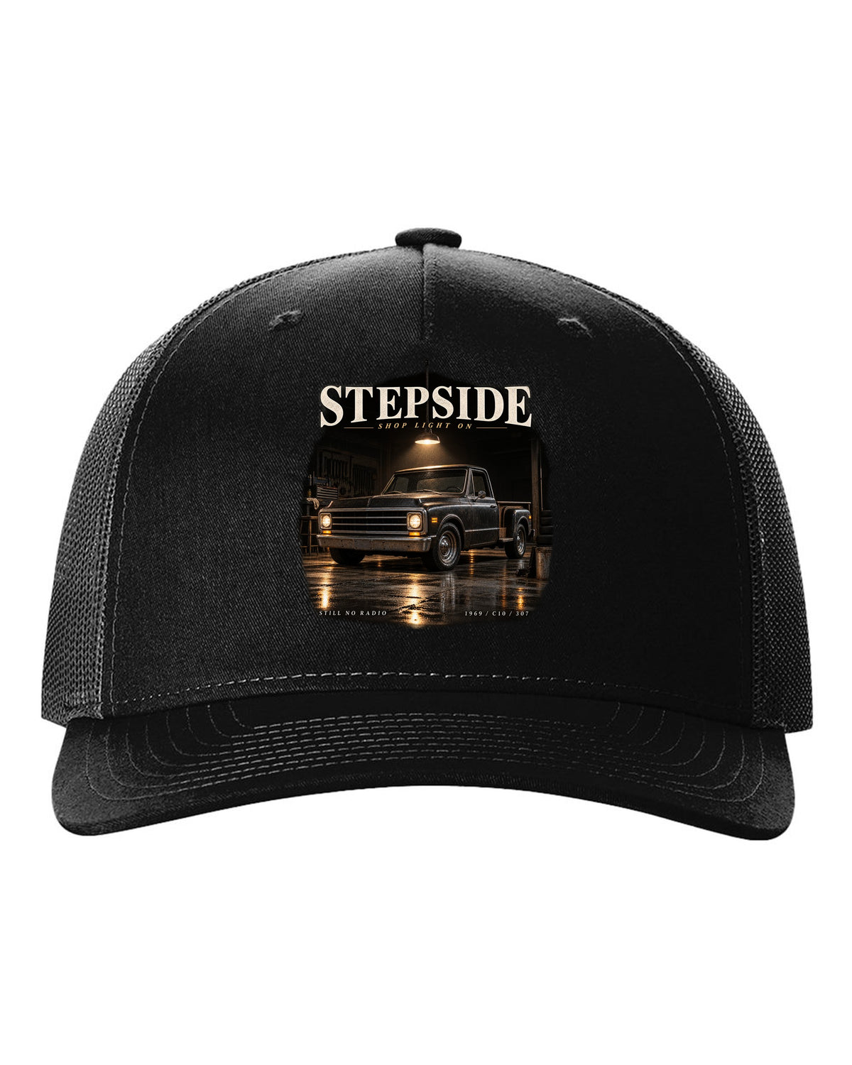 Chevy C10 Stepside under a shop light, garage night print black hat front view with the design