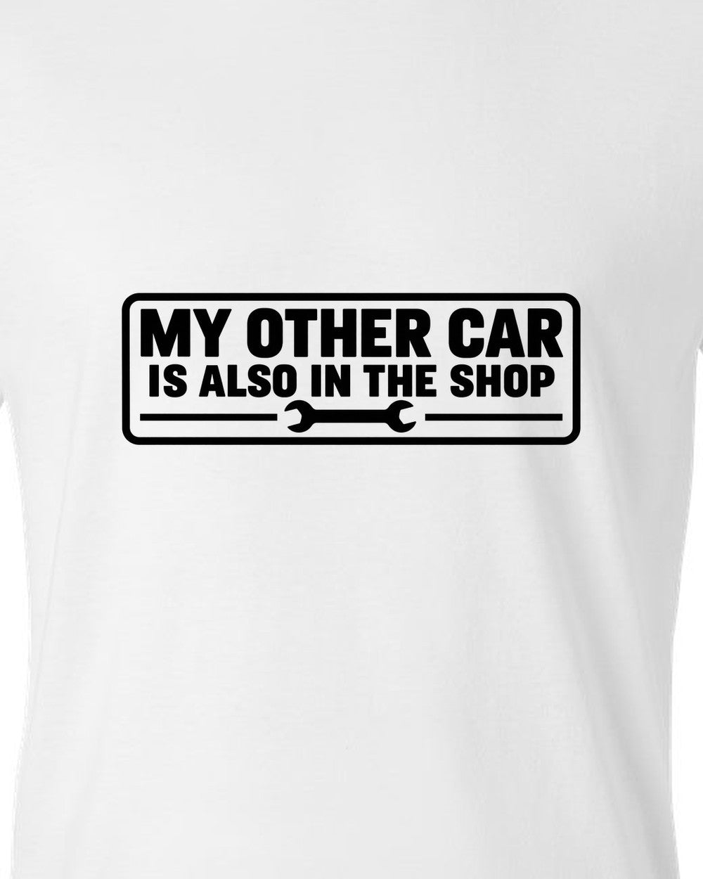Bumper sticker rectangle with a small wrench icon white t-shirt close-up