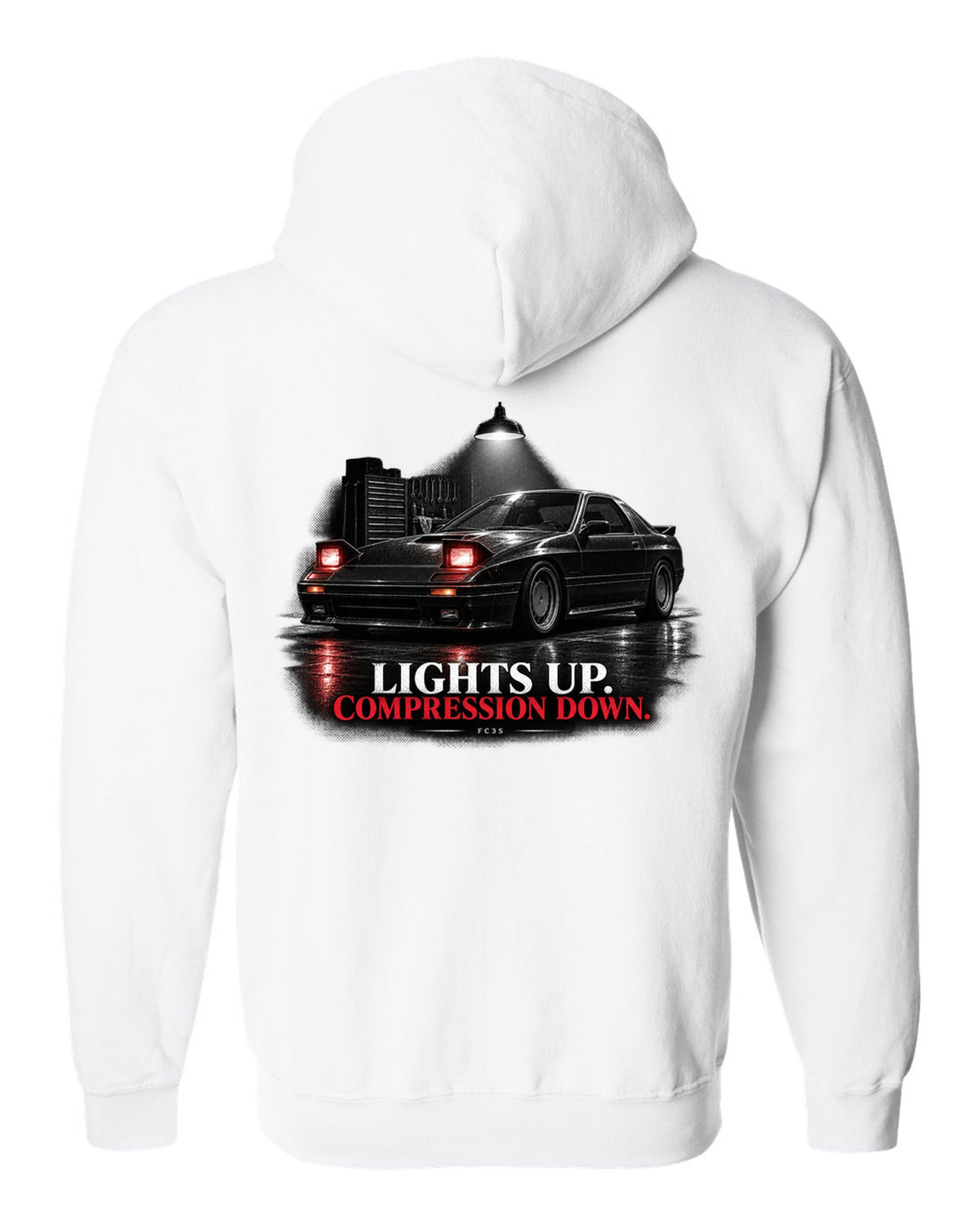 Low front three-quarter Mazda RX-7 FC3S Turbo II in a garage at night white zip hoodie back view with the design