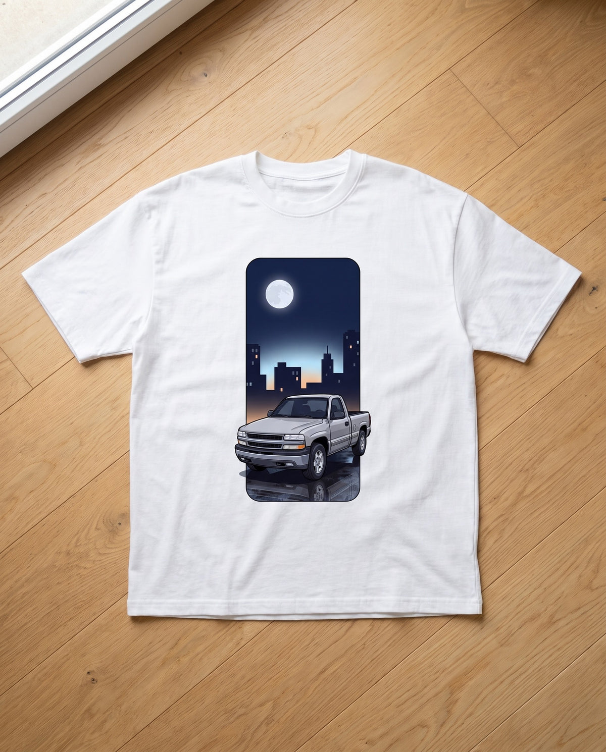 White heavyweight tee with a tall custom night-city illustration of a customer's pickup truck
